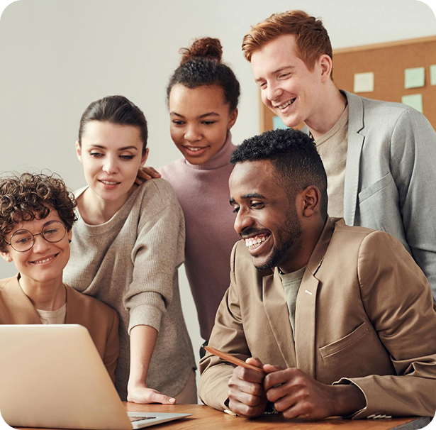 Diverse team smiling and collaborating around a laptop