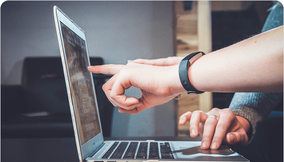 Two hands pointing and typing on a laptop
